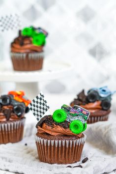 three cupcakes with monster trucks on them