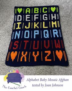 the alphabet baby mosaic afghan is on the floor with its name written in different colors