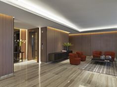 a living room with wood paneling and orange chairs