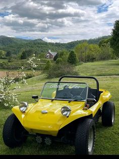 a yellow dune buggy parked in the grass