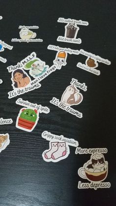 many different stickers on a black surface with white writing and pictures in the middle