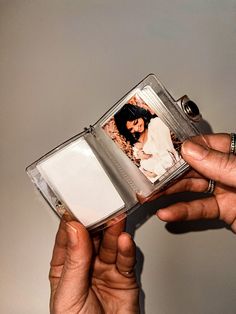 two hands holding an open photo album with a couple on the front and back cover