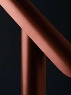 a close up view of the top of a pink metal object on a black background