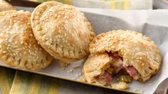 three pastries with sesame seeds and meat