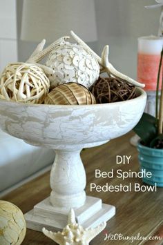 a white bowl filled with decorative items on top of a wooden table