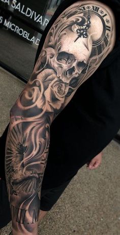 a man's arm with a clock and skull tattoo on the left side of his arm