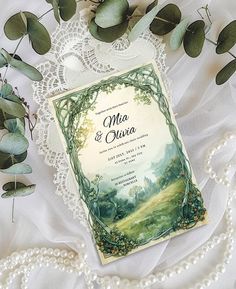 a wedding card on top of a lace doily next to flowers and greenery