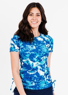 Adele Swim Top Fit & Sizing Tight Fit Sleeve Length 6.25” (Size S) Top Length 26.2” (Size S) If you are between sizes, or in doubt, please size up. Features Short Sleeve Round Neckline Does not feature a Built-in Bra Side ruching creates a flattering cinched look UPF50+ Sun Protection Quick Dry Care Rinse in cold water to wash off any chemicals, chlorinated water or saltwater Machine wash in cold water on gentle cycle Lay flat to dry in the shade Material 8 Fitted Short Sleeve Activewear For Spring, Fitted Short Sleeve Spring Activewear, Fitted Crew Neck Activewear For Summer, Fitted Moisture-wicking Tops, Fitted Blue Activewear For Summer, Swim Capris, Tie Tops, Swim Skort, Swim Bra