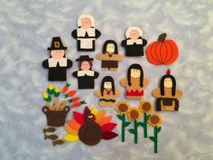 a group of paper cut outs sitting on top of a snow covered ground next to flowers and pumpkins