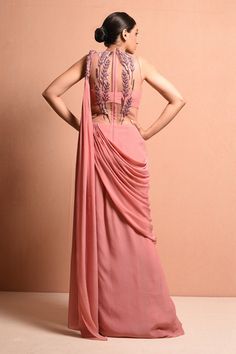 Rose pink draped saree gown with  3D embellished twisted drape shoulder and embellished leaves with 3D resham dori work, pearl, sequin work and glass bead work bodice.
Component: 1
Embellished
Neckline: V neck
Sleeve Length: Sleeveless
Fabric: Crepe
Color: Pink

Sheer back
Closure: Back zip - Aza Fashions Draped Saree Gown, Embellished Saree, Saree Gowns, Dori Work, Draped Saree, Gown For Women, Saree Gown, Embellished Neckline, Drape Saree