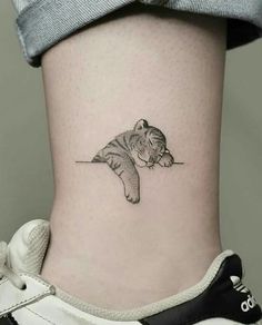 a small tiger tattoo on the side of a woman's lower back ribcage