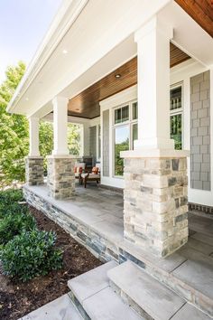 a porch with stone steps leading up to the front door