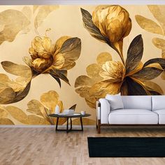 a white couch sitting in front of a wall with gold flowers on it's side