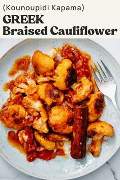 a white plate topped with fried cauliflower next to a fork