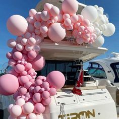 pink balloons are attached to the back of a boat