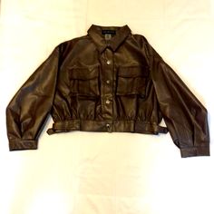 Brand New Never Worn Versona Brown Jacket. Size Large, 55% Polyurethane, 45% Rayon Lining. This Jacket Sits On Or Above The Waistline. Two Pockets On The Front. 5 Snap Buttons On The Front. Long Sleeve With Draw Belt At The Bottom On Both Sides. Wear Jacket With A Dress, Jeggings, Or Skirt. Have Fun With It! Utility Long Sleeve Leather Jacket For Spring, Utility Leather Jacket With Long Sleeves For Spring, Utility Style Long Sleeve Leather Jacket For Spring, Utility Leather Jacket For Fall Workwear, Trendy Collared Faux Leather Outerwear, Winter Workwear Cropped Faux Leather Jacket, Winter Workwear Faux Leather Cropped Jacket, Winter Work Faux Leather Cropped Jacket, Fall Biker Jacket With Faux Front Pockets