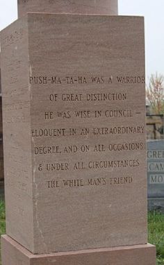 a monument with writing on it in the grass