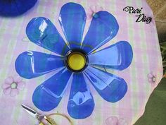 there is a blue flower painted on the table with scissors and some other crafting supplies