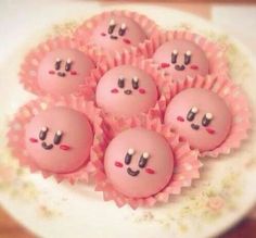 there are some pink cake balls with faces on them