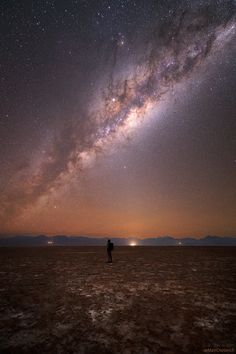 a man standing on top of a dry field under a night sky