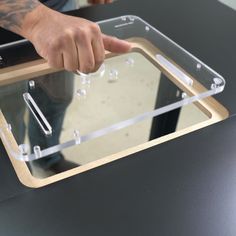 a person is pointing at something on a table with a glass screen in front of them