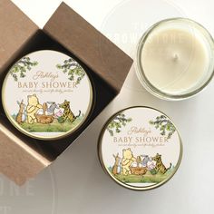 a candle and tin with winnie the pooh baby shower on it next to a box