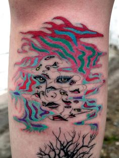 an artistic tattoo on the leg of a person with a tree and clouds in the background