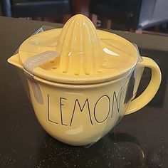 a yellow lemon squeezer sitting on top of a table next to a black counter