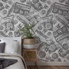 a bedroom with a wallpaper that has many clocks on it and a plant in the corner