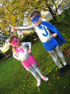 two children dressed up as superheros in the grass