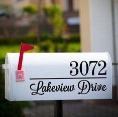 a white mailbox with a red marker on it's side and the address is 3002 lakeview drive