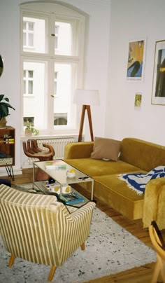 a living room filled with furniture next to a window and a rug on the floor