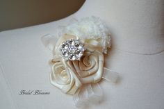 a close up of a dress with a flower and brooch on the back of it