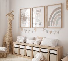 a room with some pictures on the wall and stuffed giraffe in the corner