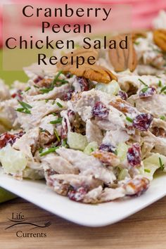 a white plate topped with chicken salad and pecans