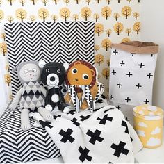 three stuffed animals sitting on top of a black and white blanket