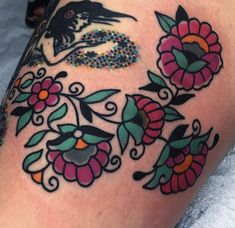 a woman's thigh with flowers and birds on it