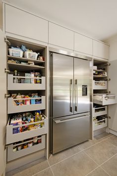 a stainless steel refrigerator in a kitchen with lots of food on the shelves and drawers