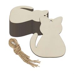 a wooden cat ornament with a string attached to it and a piece of wood that has been cut into the shape of a cat