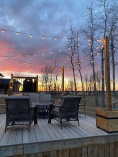 a deck with patio furniture and string lights