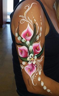 a woman with a tattoo on her arm has flowers painted on the side of her shoulder