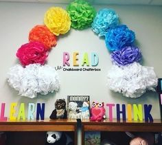 there are many books on the shelves in front of the rainbow sign and stuffed animals