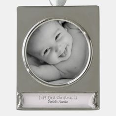 a silver christmas ornament with a baby's photo in the center and text