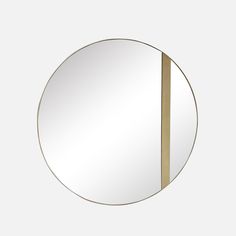 a round mirror with a gold strip in the middle