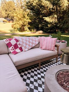 a couch sitting on top of a black and white checkered floor next to a fire pit