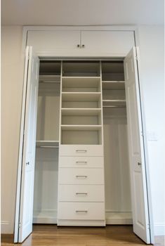 an empty closet with white drawers and doors