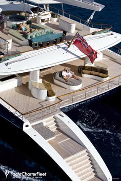 a large white boat floating in the ocean next to a dock with people on it