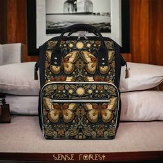 a black and gold backpack sitting on top of a bed next to pillows in a room