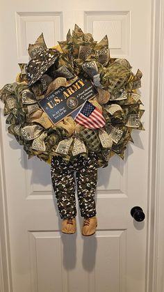 a wreath made out of dollar bills with an american flag on it, hanging from the front door