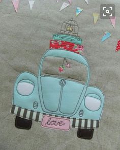 a blue car with a birdcage on top is embroidered onto the side of a blanket